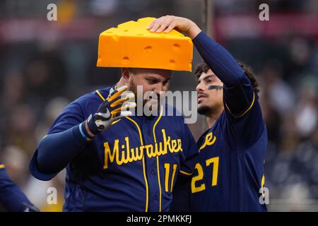 Milwaukee Brewers' Willy Adames, right, places a cheesehead hat on