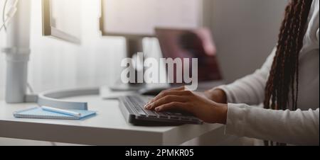 Close up shot of happy young woman working on computer, female hands typing on keyboard Stock Photo