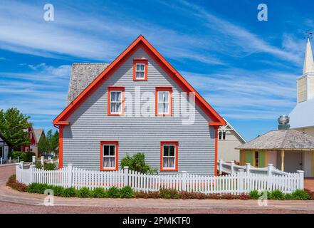 Side-gabled dwelling with orange trim accents that pop against the blue sky. Avonlea Village replicates houses from the time of Anne of Green Gables. Stock Photo