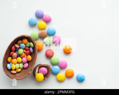 Sweet Easter concept. Colorful and chocolate easter eggs with sweet dragee on white background with copy space. Design for a greeting card for the Eas Stock Photo