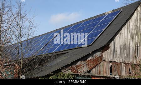 Many solar panels on the roof of an old barn Stock Photo