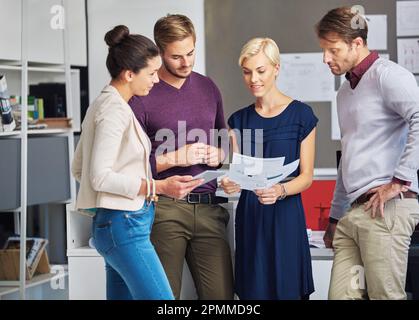 Making headway on their joint project. a group of designers working in their office. Stock Photo