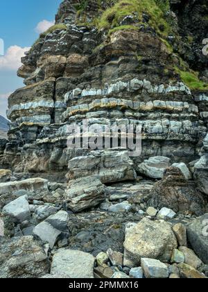 Banded sedimentary rock layers of sandstone, siltstone and mudstone in the Staffin Shale formation, Scaladal bay, Isle of Skye, Scotland, UK Stock Photo