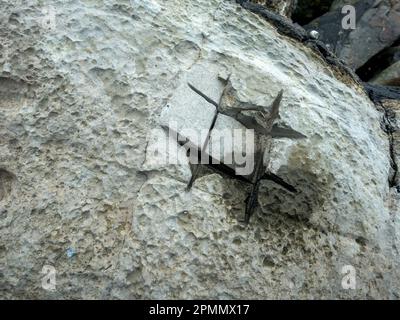 Crude rock 'core' sampling using angle grinder slit cuts into boulder on Elgol beach, Isle of Skye, Scotland, UK Stock Photo