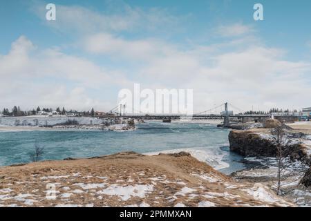 Iceland's iconic Ölfusárbrú bridge a 2-lane, 84m vehicular steel wire suspension bridge over Ölfusá river connecting Ring Road One with Selfoss Town. Stock Photo