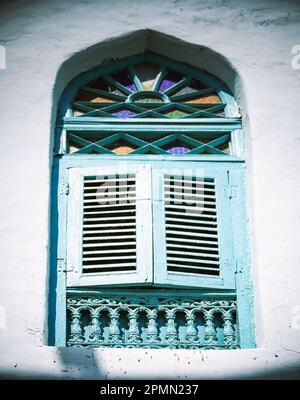 A window with wooden shutters in a house in the old quarter of Muscat, Oman Stock Photo