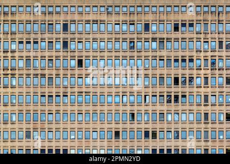 Repeated pattern of a high buidling facade with windows and frame in crowded urban life Stock Photo