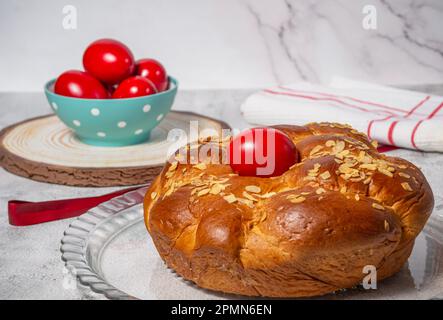 Easter traditional bread, greek tsoureki and red eggs on a table Stock Photo
