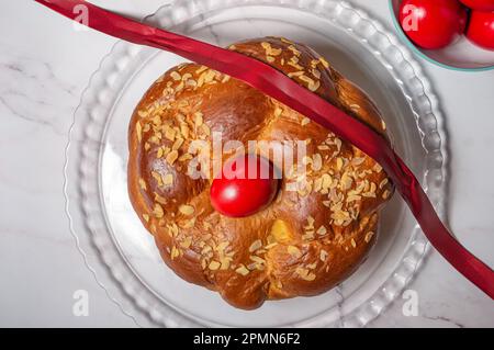 Easter traditional bread, greek tsoureki and red eggs on a table Stock Photo