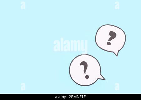 Speech bubbles with question marks on blue background Stock Photo