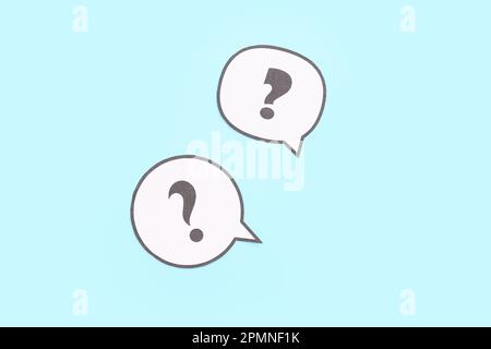 Speech bubbles with question marks on blue background Stock Photo