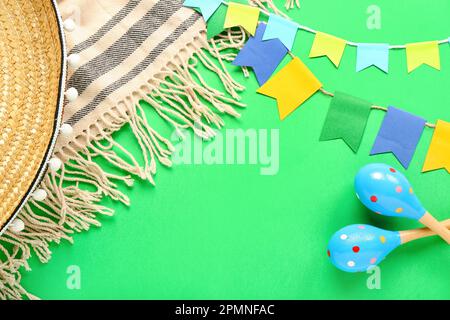 Frame made of Mexican maracas, flags and serape on green background Stock Photo