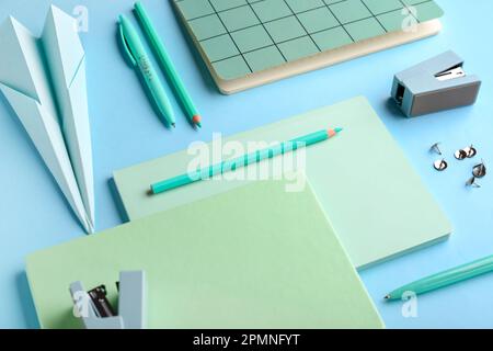 Composition with stationery supplies and paper plane on blue background Stock Photo