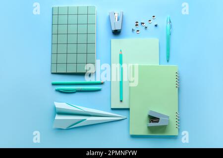 Composition with stationery supplies and paper plane on blue background Stock Photo