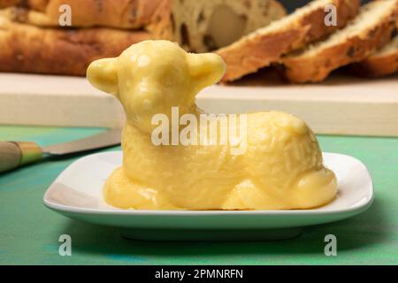 Traditional easter butter lamb in front of slices od an easter bread close up Stock Photo