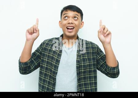 Young Asian man smiling and pointing index fingers up Stock Photo