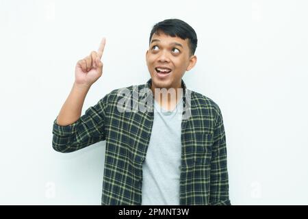 Young Asian man smiling and pointing index finger up Stock Photo