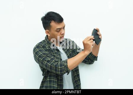 Young Asian man checking his empty wallet Stock Photo