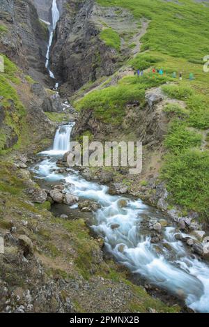 Tourists view a waterfall in Iceland; Iceland Stock Photo