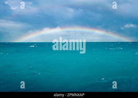 Rainbow arcs over the Great Barrier Reef, the world's largest coral reef; Queensland, Australia Stock Photo