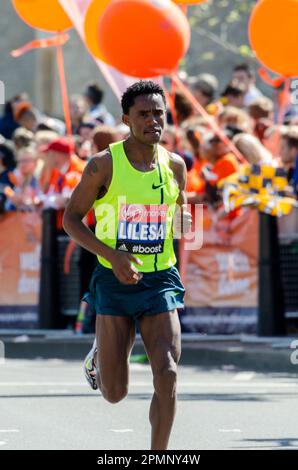 Feyisa Lilesa competing in the London Marathon 2014, passing through Tower Hill near the Tower of London, UK. Ethiopian elite athlete Stock Photo