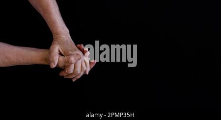 palms of old man on a black background. Stock Photo