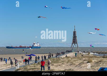 People, flying kites, freight ship, sea marker Kugelbake, North Sea, Elbe, Cuxhaven, Lower-Saxony, Germany Stock Photo