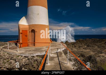 Ocean crashing on the rocks behind Folly Point Lighthouse; Port Antonio, Jamaica Stock Photo