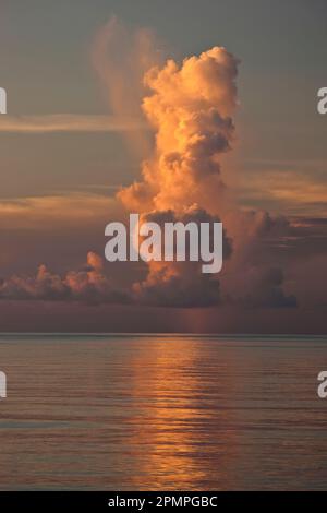 Tall vertical cloud at sunset over the ocean; Seychelles Stock Photo