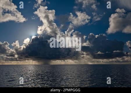 Dark storm cloud drops rain over the ocean; Seychelles Stock Photo