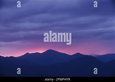 Setting sun drops behind the Adirondack's Mount Marcy, New York, USA; New York, United States of America Stock Photo