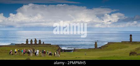 Tourists stand in front of a Moai at Ahu Tahai Ceremonial complex, Rapa Nui National Park on Easter Island; Easter Island Stock Photo