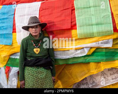 Young woman selling prayer flags in Lhasa, Tibet; Lhasa, Tibet Stock Photo