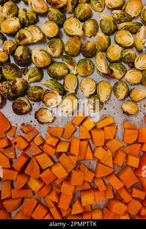 Oven roasted pumpkin and brussel sprouts on the tray, top view. Thanksgiving food preparation Stock Photo