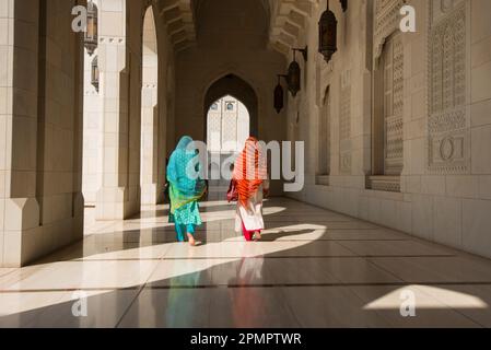Two traditionally dressed women walking through a corridor of the Sultan Qaboos Grand Mosque. Stock Photo