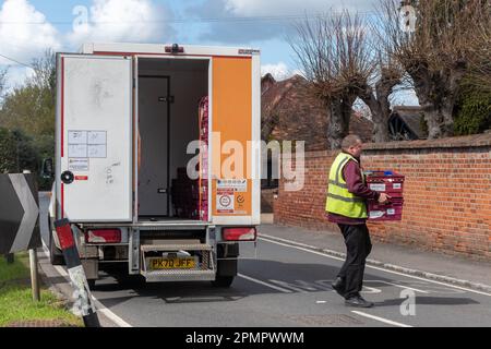 A Sainsbury's delivery van  with the driver delivering groceries to a house in Sonning-on-Thames village in Berkshire, England, UK Stock Photo