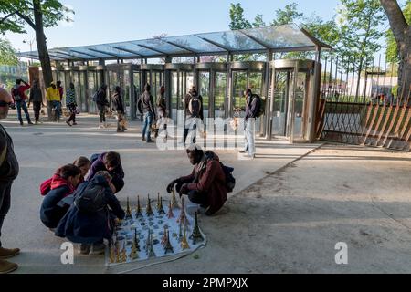 Different seller waiting around the Eiffel tower for tourists to sell souvenirs. Stock Photo