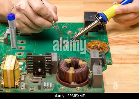Soldering iron. Repairing electronic component. Microelectronics engineering concept Stock Photo