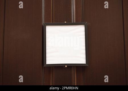 blank vintage wooden sign board hanging on wooden door in modern cafe restaurant, copy space for text advertising, advertisement marketing and small Stock Photo