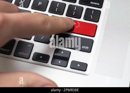 Online International Business concept: Computer key with the China flag on it. Male hand pressing computer key with China flag Stock Photo
