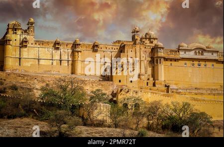 Amber Fort illuminated by warm light of the rising sun and reflected in the lake. Famous Rajasthan landmark, India Stock Photo