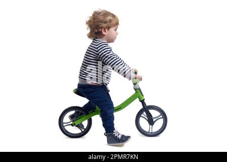 side view of a baby boy bicycling a bicycle on white background Stock Photo