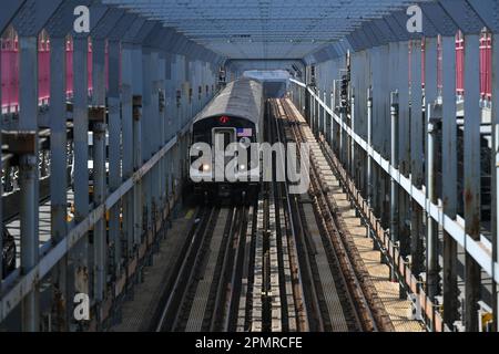 A subway train crosses over the Williamsburg Bridge on April 14, 2023 in New York City. Stock Photo