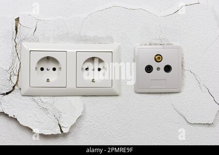 Wall plaster loosens around sockets Stock Photo