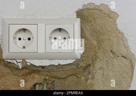 Wall plaster loosens around sockets Stock Photo