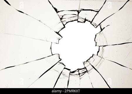 A hole in the window, cracks in the glass. The effect of a broken window texture on a white background Stock Photo