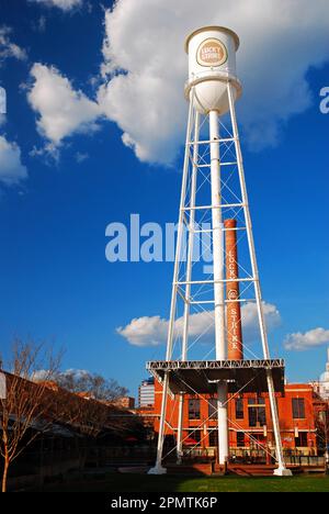 A large water tower, bearing the brand of a cigarette company, is a reminder of the tobacco processing plant that was once prevalent in Durham, NC Stock Photo