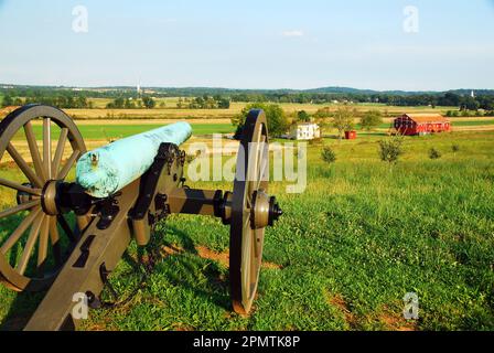 A Civil War era cannon looks down on the farm structures in Gettysburg National Military Park in Pennsylvania Stock Photo