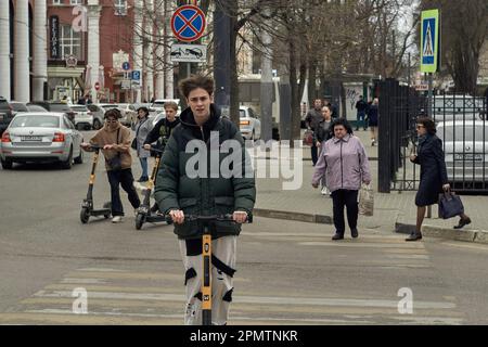 Voronezh, Russia. 12th Apr, 2023. Young scooter riders on Pushkinskaya Street in Voronezh. By mid-April, spring warmth came to Voronezh. In a city with a million inhabitants, the last snow has melted, and people have changed their winter clothes to lighter ones. Credit: SOPA Images Limited/Alamy Live News Stock Photo