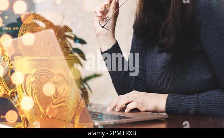 Woman using laptop with bitcoin hologram. Cryptocurrency concept. Double exposure. Stock Photo